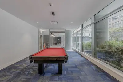a red pool table in a room with windows at 25 Days Minimum - Luxury and Modern Downtown Apartment - Do not send request for less than 21 days in Vancouver