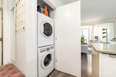 a white laundry room with a washer and dryer at 25 Days Minimum - Luxury and Modern Downtown Apartment - Do not send request for less than 21 days in Vancouver