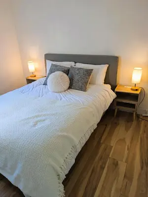 a bedroom with a large bed with two lamps at Private room in Chic Main St suite in Vancouver