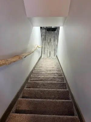 a staircase leading up to a room with a stair case at Cowboy Cabin- Lakefront Rental Northern Saskatchewan