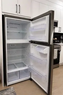 an empty refrigerator with its door open in a kitchen at The Bear Cave - Artist-Inspired Suite in Langford