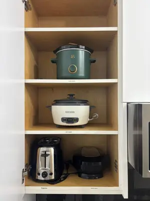 a cabinet with a slow cooker and a toaster at The Bear Cave - Artist-Inspired Suite in Langford