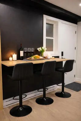 a kitchen with a table with two black bar stools at The Bear Cave - Artist-Inspired Suite in Langford