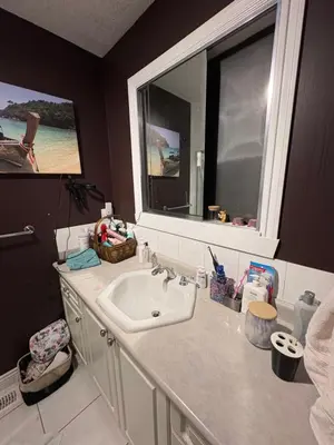 a bathroom with a sink and a large mirror at Oasis in Surrey