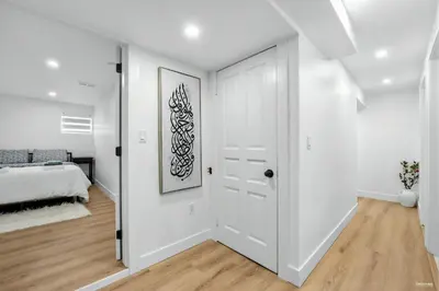 a white bedroom with a white door and a bed at Shanaz house in Vancouver