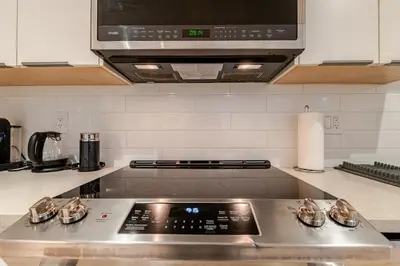 a kitchen with a stove top with a microwave at Modern Bright Suite Self Check-In in North Vancouver