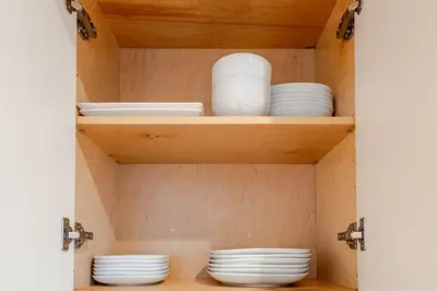 a cupboard with plates and dishes in it at Modern Bright Suite Self Check-In in North Vancouver