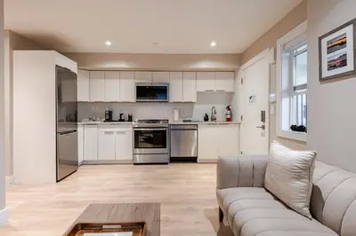 a living room with a couch and a kitchen at Modern Bright Suite Self Check-In in North Vancouver