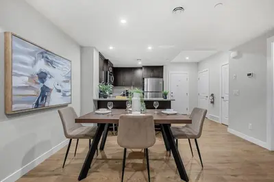 a kitchen and dining room with a table and chairs at Herron Rise Luxury 1 Bedroom Basement Suite in Calgary