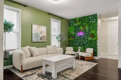 a living room with a couch and a green wall at Luxury Haven | Pool | Hot Tub & Sauna |Outdoor BBQ in Calgary