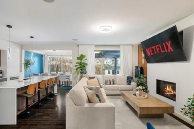 a living room with a couch and a fireplace at Luxury Haven | Pool | Hot Tub & Sauna |Outdoor BBQ in Calgary