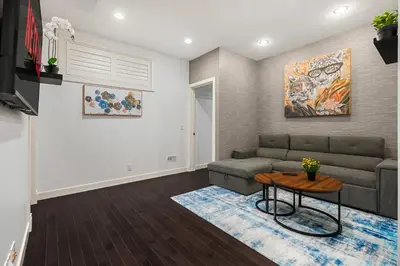 a living room with a couch and a table at Luxury Haven | Pool | Hot Tub & Sauna |Outdoor BBQ in Calgary