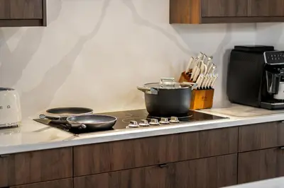 a kitchen with a stove with a pot on it at Luxury Haven | Pool | Hot Tub & Sauna |Outdoor BBQ in Calgary