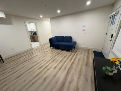 a living room with a blue chair and a table at Vancouver Downtown Cozy Room - 5-Min Walk to BC Place & Skytrain - Free Parking in Vancouver