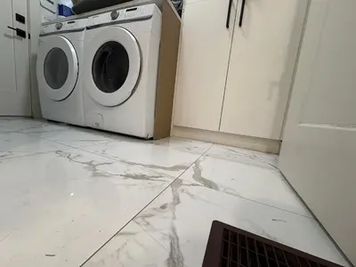 a laundry room with a washer and dryer on a marble floor at Vancouver Downtown Cozy Room - 5-Min Walk to BC Place & Skytrain - Free Parking in Vancouver