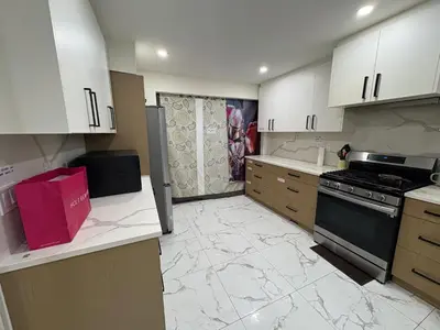 a kitchen with marble floors and white cabinets and appliances at Vancouver Downtown Cozy Room - 5-Min Walk to BC Place & Skytrain - Free Parking in Vancouver