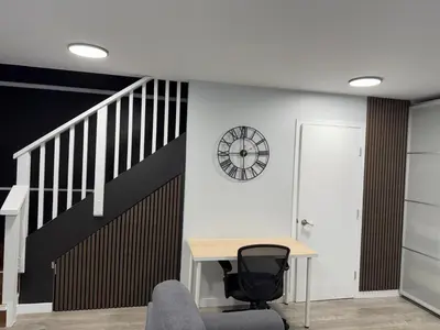 a room with a desk and a clock on a wall at Super bright and beautiful home with all you need in Delta