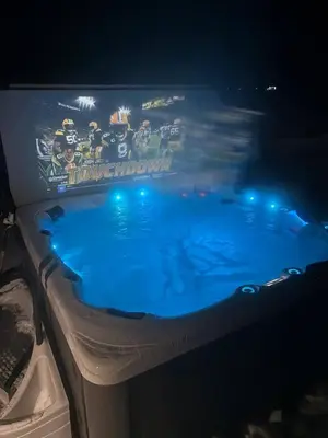 a tv showing a football game on top of a swimming pool at Spacious 4-Season Cabin with Lakefront Views in Silver Sands in Seba Beach