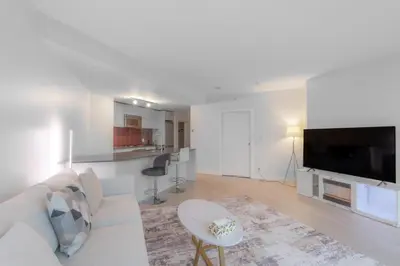 a living room with a white couch and a tv at Luxury High Rise at Gastown Near BC Place in Vancouver