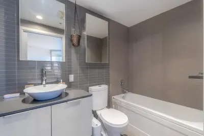a bathroom with a sink and a toilet and a tub at Luxury High Rise at Gastown Near BC Place in Vancouver
