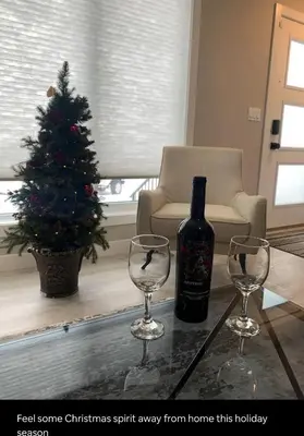 a bottle of wine and two wine glasses on a table at New townhouse in Red Deer -Family retreat in Red Deer
