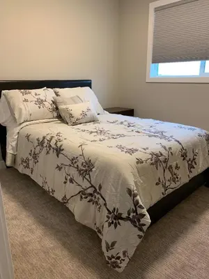 a bedroom with a bed with a blanket and a window at New townhouse in Red Deer -Family retreat in Red Deer
