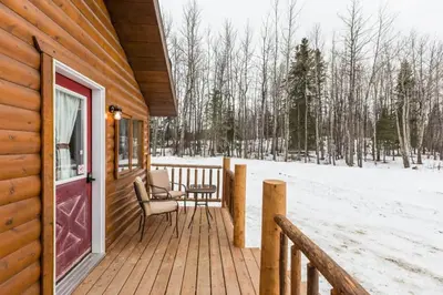 a porch of a wooden cabin with a red door at The White Tail Cabin - Bear Creek Cabins in Winfield