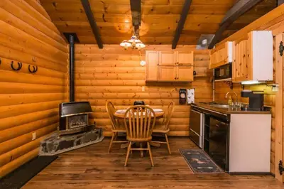 a kitchen with a table and chairs and a stove at The White Tail Cabin - Bear Creek Cabins in Winfield