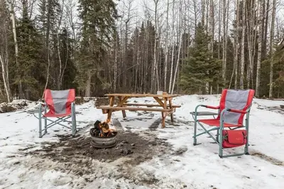 two chairs and a picnic table in the snow at The White Tail Cabin - Bear Creek Cabins in Winfield