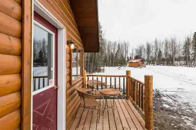 a porch of a cabin with a table and chairs at The Mustang Cabin - Bear Creek Cabins in Winfield