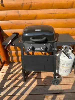 a grill sitting on a stand next to a wall at The Mustang Cabin - Bear Creek Cabins in Winfield