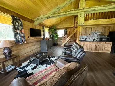 a living room with leather furniture in a log cabin at The Ram cabin - Bear Creek cabins in Winfield