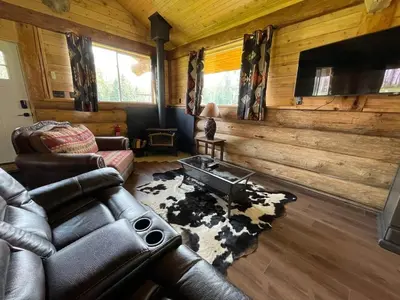 a living room with a leather couch and a rug at The Ram cabin - Bear Creek cabins in Winfield