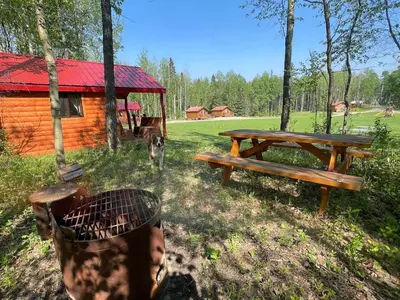 a picnic table and bench in front of a cabin at The Lynx cabin - Bear Creek Cabins in Winfield
