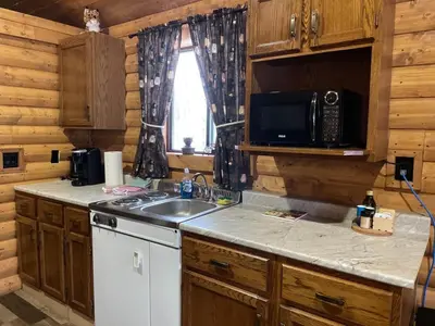 a kitchen with a sink and a microwave at The Lynx cabin - Bear Creek Cabins in Winfield