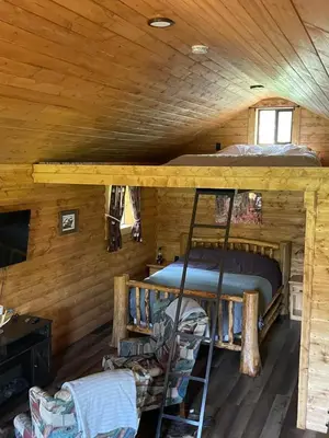 a bedroom with a bunk bed in a log cabin at The Lynx cabin - Bear Creek Cabins in Winfield