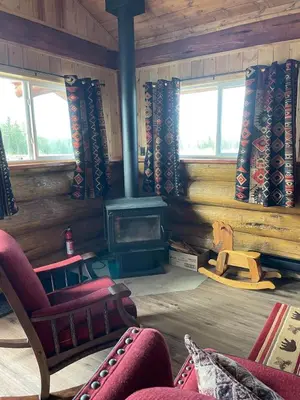 a living room with a fireplace and chairs and windows at The Deerview cabin - a part of Bear Creek Cabins in Winfield