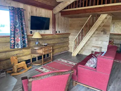 a living room with a couch and a tv in a cabin at The Deerview cabin - a part of Bear Creek Cabins in Winfield