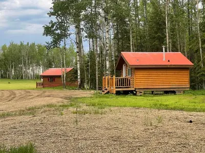 a cabin with a red roof next to a forest at The Sheep Camp cabin- Bear Creek Cabins in Winfield