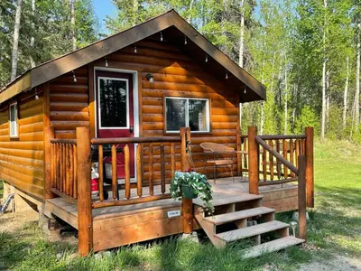 a log cabin with a porch and a staircase at The Sheep Camp cabin- Bear Creek Cabins in Winfield