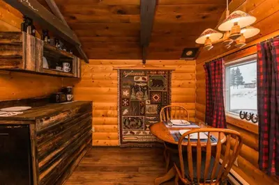 a dining room with a table and chairs in a cabin at The Sheep Camp cabin- Bear Creek Cabins in Winfield