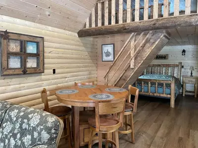 a wooden dining room with a table and a bed at The Cowboy cabin - Bear Creek Cabins in Winfield