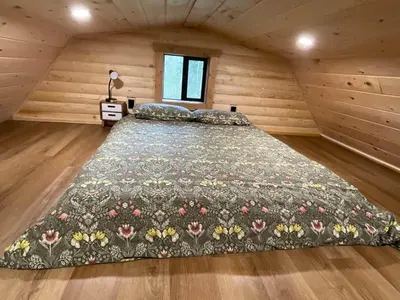 a bedroom with a large bed in a wooden room at The Cowboy cabin - Bear Creek Cabins in Winfield