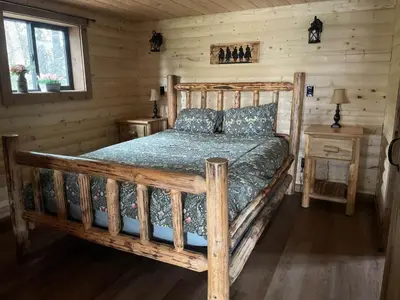 a bedroom with a wooden bed in a cabin at The Cowboy cabin - Bear Creek Cabins in Winfield
