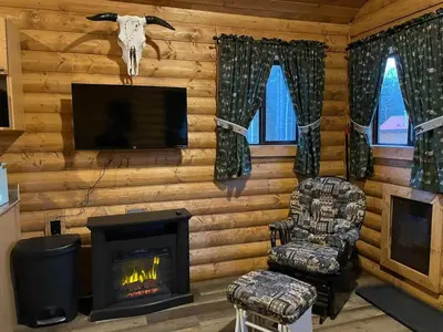 a living room with a fireplace and a tv at The Moose cabin - Bear Creek Cabins in Winfield