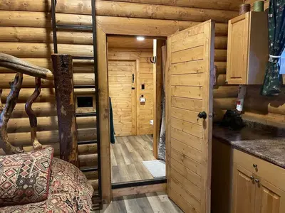 a log cabin with a door leading to a kitchen at The Moose cabin - Bear Creek Cabins in Winfield