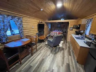 a kitchen and living room in a log cabin at The Longhorn cabin - Bear Creek Cabins in Winfield