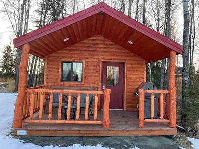 a log cabin with a porch and a door at The Longhorn cabin - Bear Creek Cabins in Winfield
