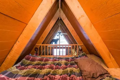 a bed in a room with a large window at The Papa Bear Cabin - Bear Creek Cabins in Winfield