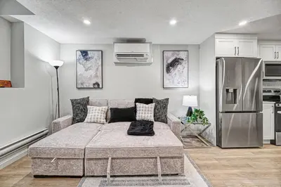 a living room with a couch and a refrigerator at Stylish 2BR Townhome - Near YYC Airport - Free Parking in Calgary